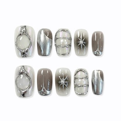 A set of elegant short square nail art designs featuring metallic details, pearls, and glossy finishes in neutral colors.
