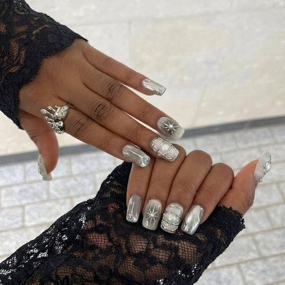 A set of elegant short square nail art designs featuring metallic details, pearls, and glossy finishes in neutral colors.