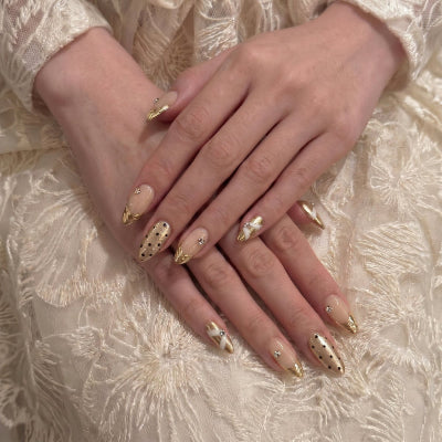 Model wearing Liquid Luxury  Champagne Drape almond press-on nails — lifestyle close-up | GlossyMuse