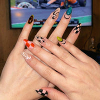 Ten colorful nail designs featuring patterns in black checked, white, red checked, and green.