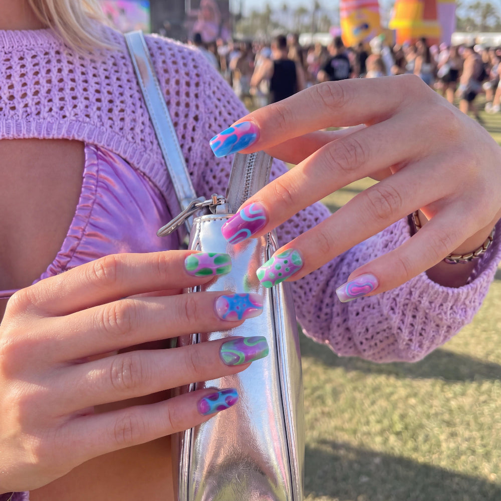 Ten colorful nail art designs in shades of blue, pink, green, and purple with abstract patterns.