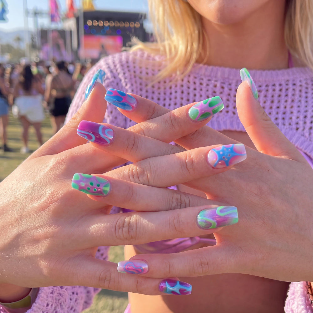 Ten colorful nail art designs in shades of blue, pink, green, and purple with abstract patterns.