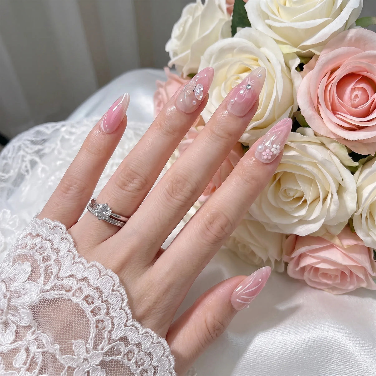 Garden of Forever pink ombre bridal nail art with iridescent butterfly, 3D cherry blossom flowers, pearl accents and swirl designs on almond nails, styled with roses and diamond wedding ring