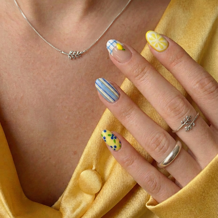 Model wearing Lemon Stripe Spritz almond press-on nails — lifestyle close-up | GlossyMuse
