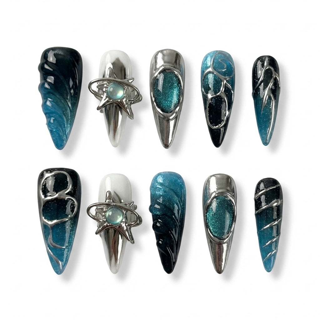 Set of stylish stiletto nails featuring teal and black designs with shiny metallic accents.