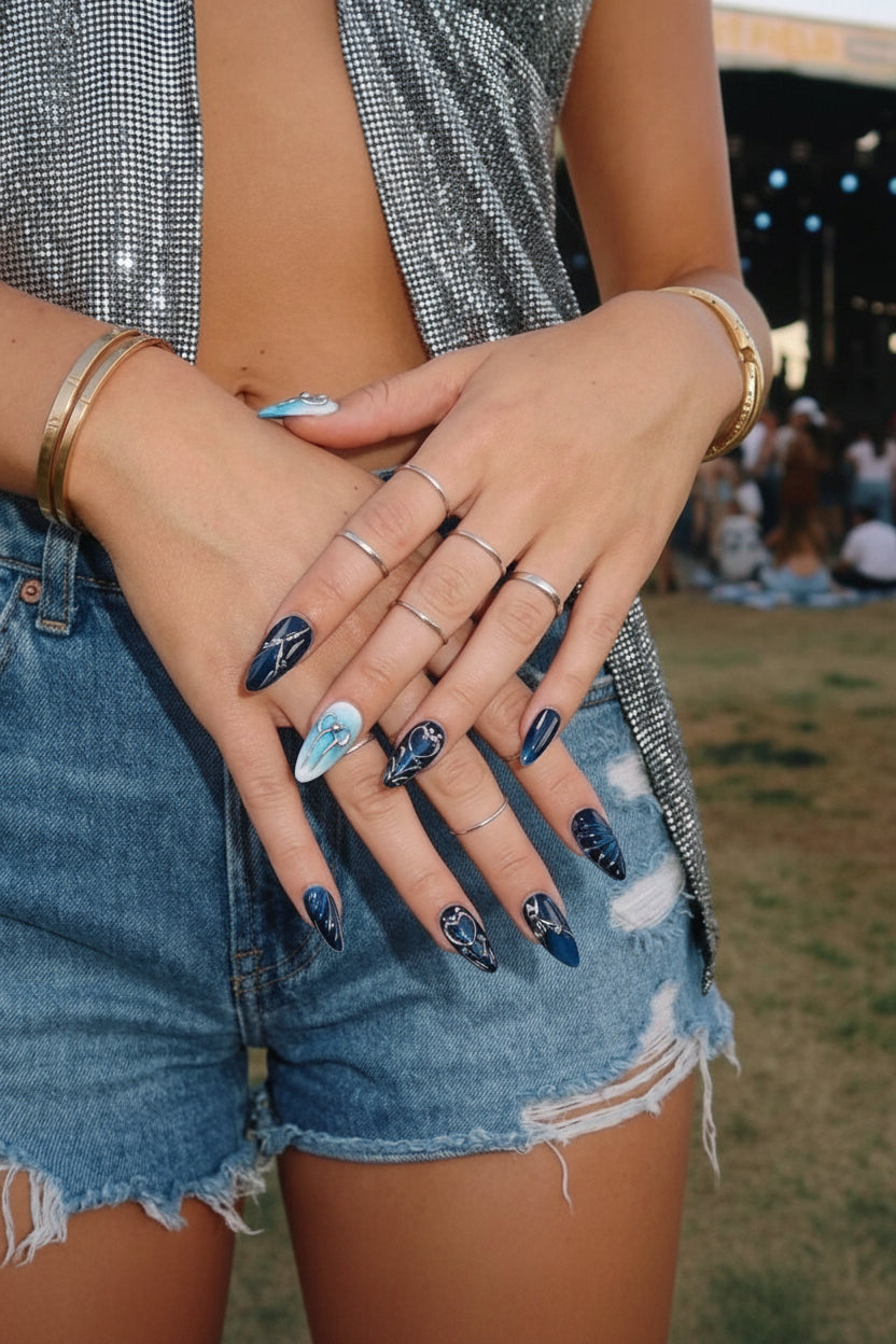Ten almond nail art designs in blue and navy colors, featuring patterns and silver accents.