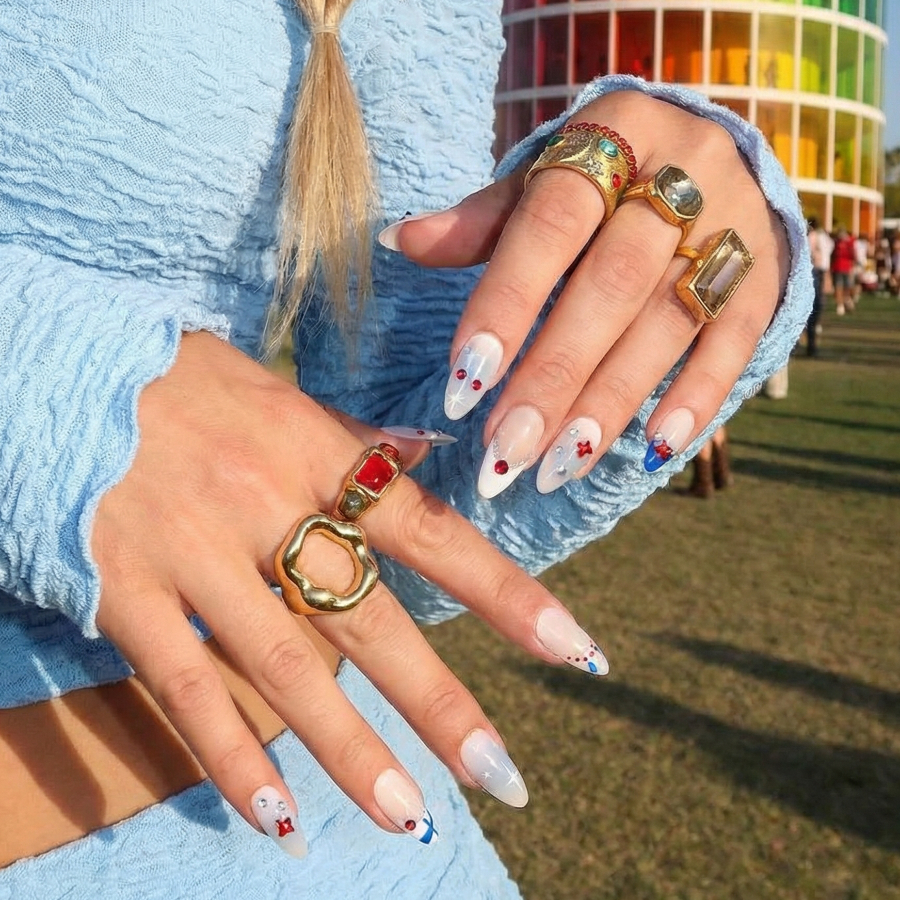 Ten decorative almond nails with festive designs, including bows, stars, and beads.