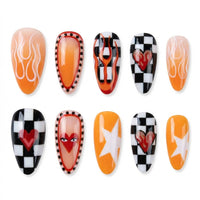 Nail art design with orange and black themes, featuring flames, hearts, and checkered patterns.