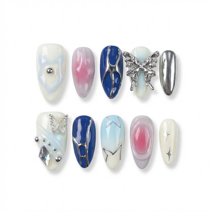 Ten decorative almond nail designs in various colors, featuring gems, a butterfly, and shiny accents.