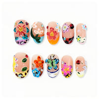 Colorful nail art set with flowers, butterflies, ladybug and gems on nude nails.