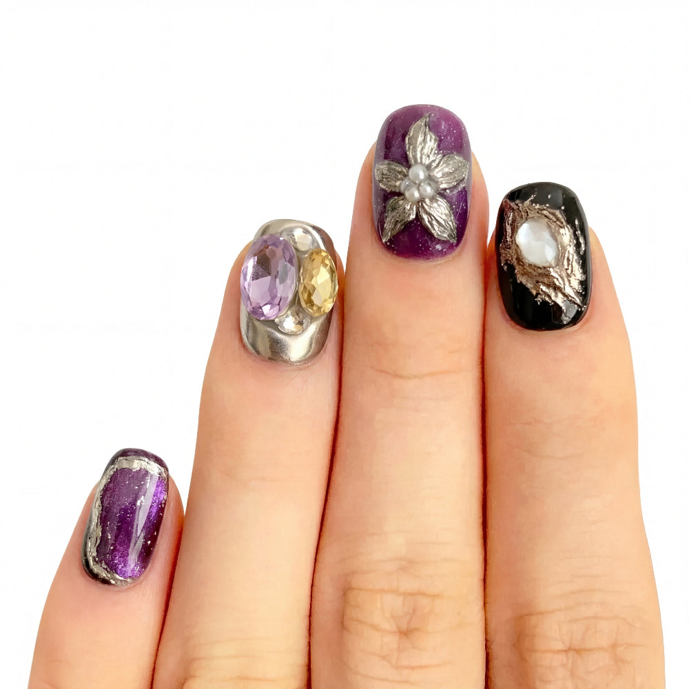 Model wearing Royal Purple & Black Gemstone Floral almond press-on nails — lifestyle close-up | GlossyMuse